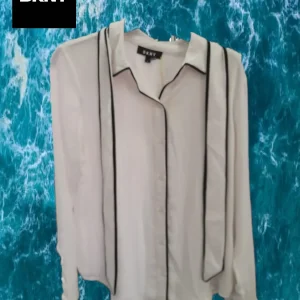 CAMISA MUJER BLANCA MANGA LARGA CON BORDES NEGROS DKNY ( TARA MANCHA PARTE FRONTAL DERECHA )