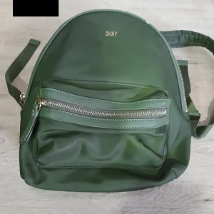 MOCHILA VERDE TELA DKNY ( TARA PEQUEÑA MARCHA EN PARTE SUPERIOR Y MANCHA EN PARTE BAJA )
