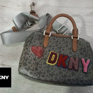 BOLSO MINI MARRÓN CON ESTAMPADO DKNY Y LOGO DKNY EN COLORES , ASA LARGA DE TELA ( TARA ROTO ENGANCHE ASA )