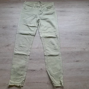 PANTALÓN BEIGE PITILLO ESTILO VAQUERO DESHILACHADO EN BAJOS SEÑORA