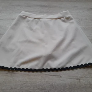FALDA-PANTALÓN BEIGE ROSADO CORTA CON RIBETE NEGRO