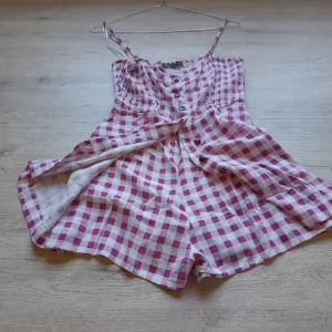 MONO CORTO TIRANTES BLANCO Y CUADROS FUCSIA (TIENE UN BOTÓN DESCOSIDO)