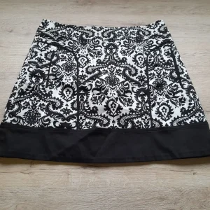 MINI FALDA BLANCA CON ESTAMPADO FLORAL NEGRO Y CIERRE DE CREMALLERA