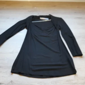 CAMISETA M/L NEGRA CON DETALLE EN PECHO